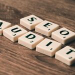 Tuiles de Scrabble orthographiant l'audit SEO sur une surface en bois, symbolisant les stratégies de marketing numérique.