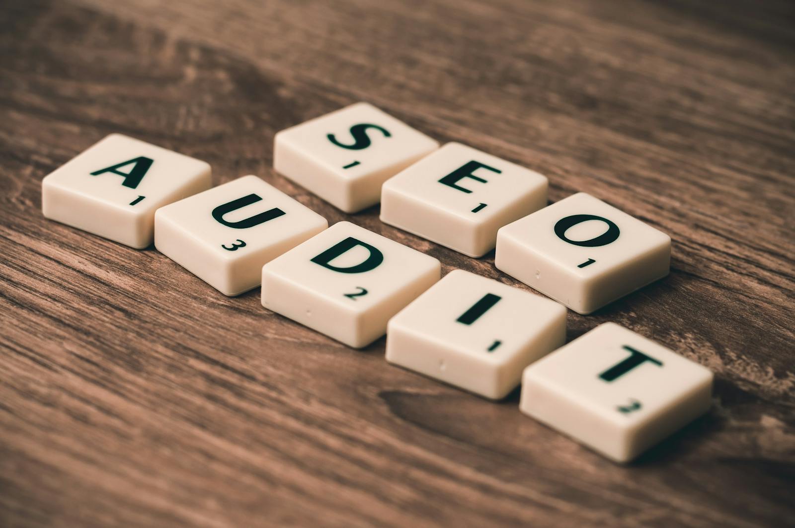 Tuiles de Scrabble orthographiant l'audit SEO sur une surface en bois, symbolisant les stratégies de marketing numérique.