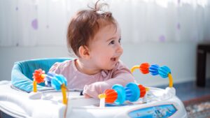 Un bébé joyeux profitant du temps de jeu dans un trotteur dynamique à l'intérieur.